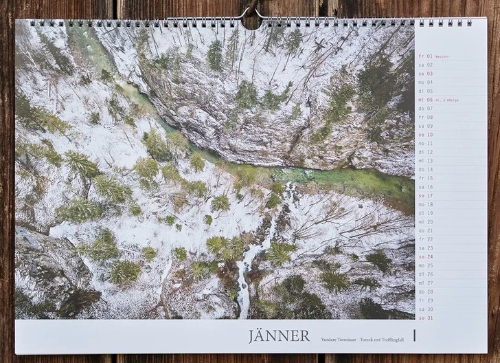 Kalenderblatt Jänner mit verschneiter Waldlandschaft und Fluss aus der Vogelperspektive